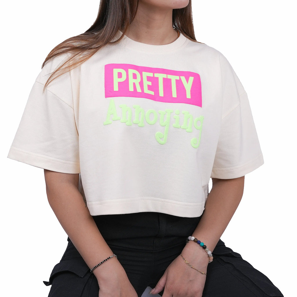 Person wearing a white t-shirt with 'PRETTY Annoying' text in pink and green.
