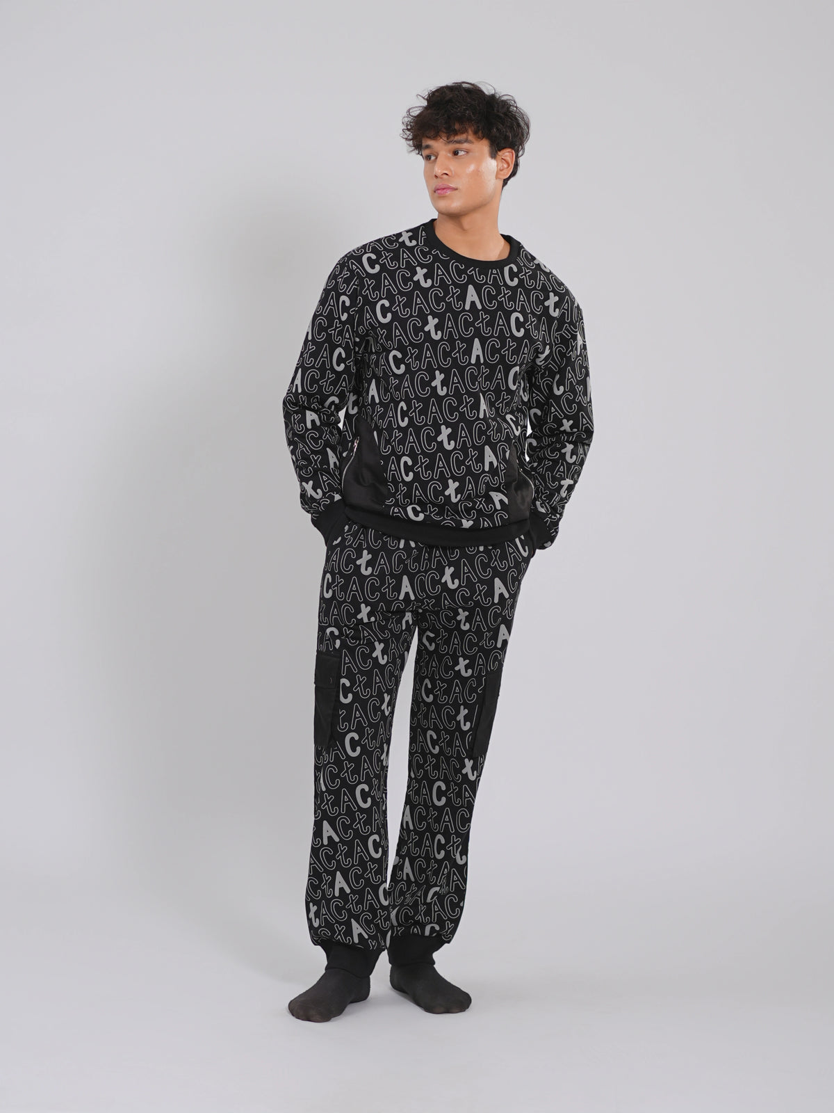 Person wearing a black pajama set with white lettering on a gray background