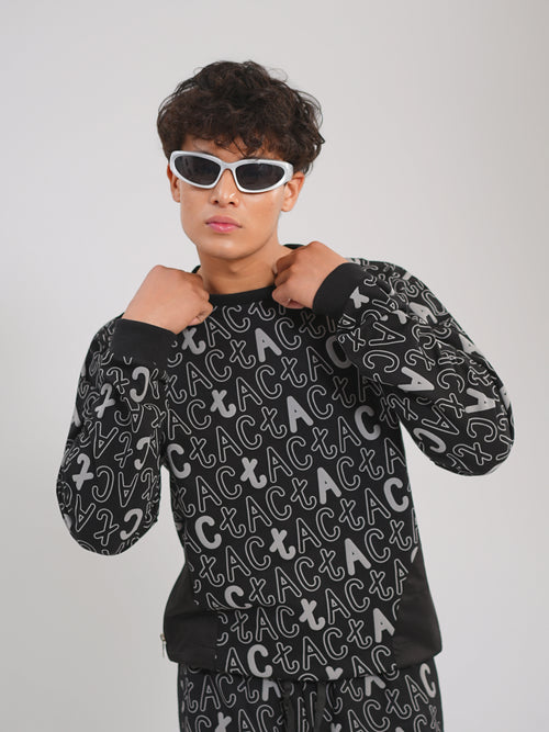 Person wearing a black long-sleeve shirt with white patterns on a plain background