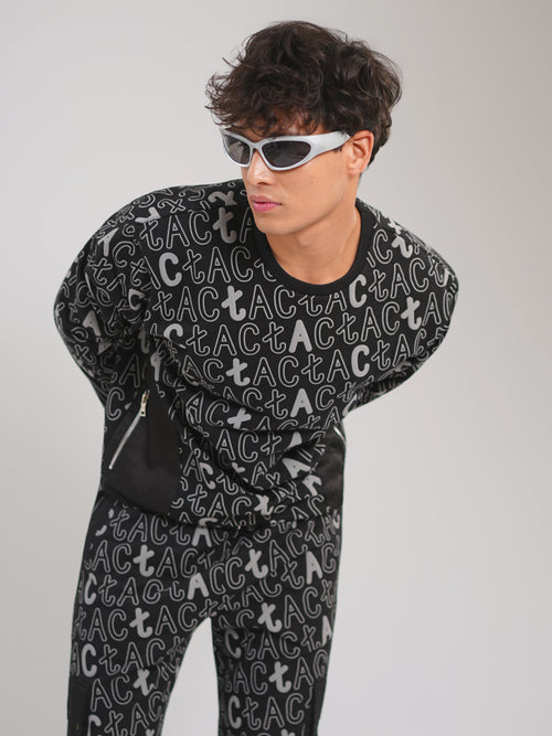 Person wearing a black outfit with white text pattern on a plain background