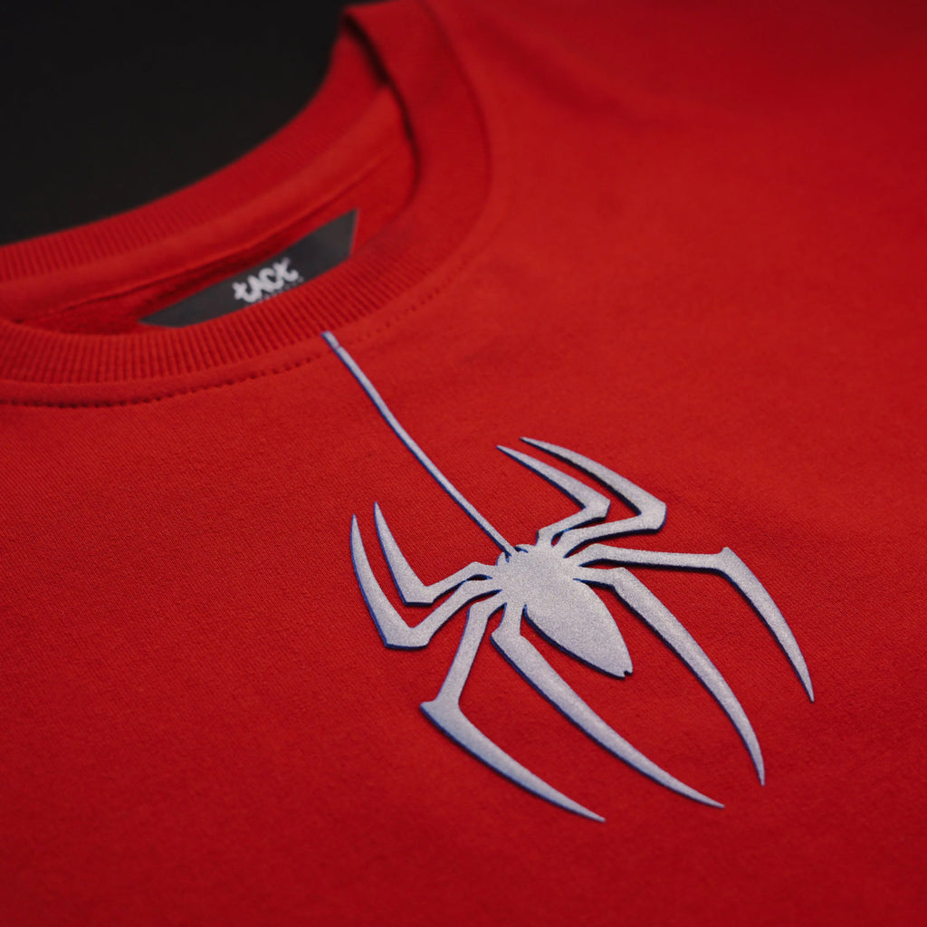 Red shirt with a silver spider logo on a black background
